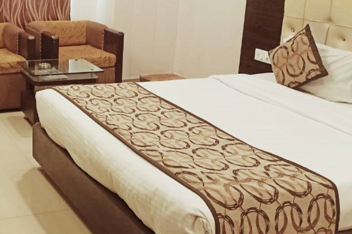 Una habitación de hotel con cama, sofá, escritorio y silla.