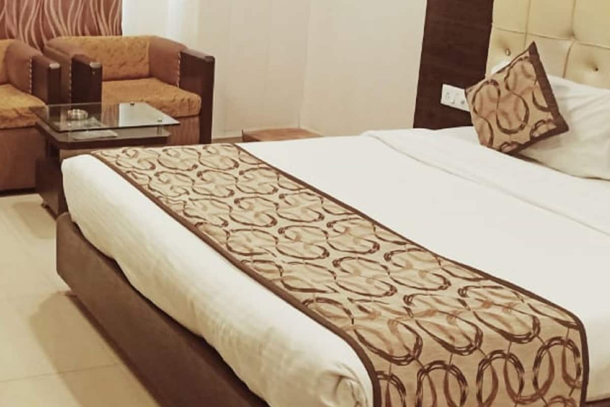 Habitación de hotel con cama, sofá, escritorio y silla.