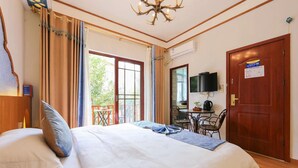 A hotel room with a bed, a desk with a chair, a television, and a door. - Edinburgh Hostel (Zhangjiajie)