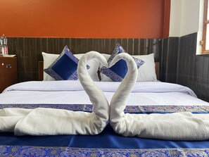 Ein Hotelzimmer mit einem Bett, Kissen und einer dekorativen Handtuchgestaltung.