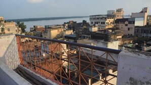 A cityscape with a river in the background and buildings of various architectural styles. - Family Guest House (Varanasi)