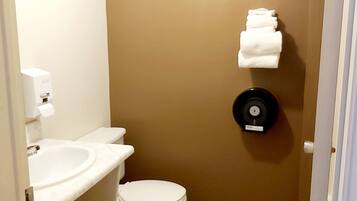A bathroom with a toilet, sink, and towel rack.