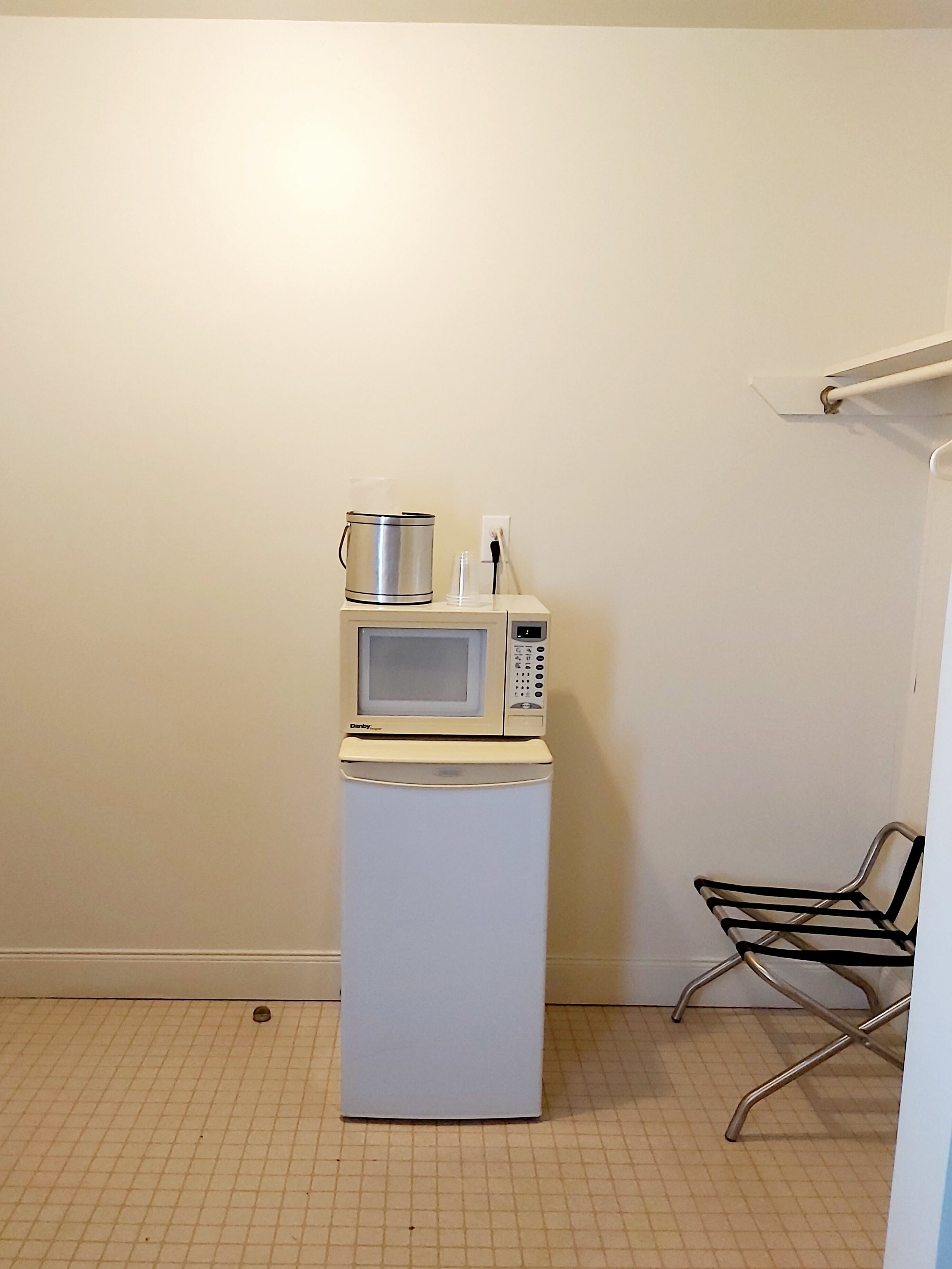 A compact kitchenette with a microwave and a small refrigerator.