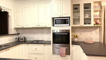 Casa familiar, varias camas, vista al patio | Cocina privada | Refrigerador, microondas, cafetera y tetera y tetera eléctrica