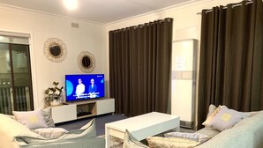 บ้านพักสำหรับครอบครัว, หลายเตียง, วิวสวนหย่อม | ห้องนั่งเล่น | ทีวีจอแบน
