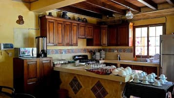 Una cocina con armarios de madera, salpicadero de azulejos y un refrigerador.