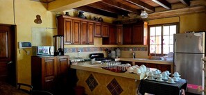 Una cocina con armarios de madera, salpicadero de azulejos y un refrigerador.
