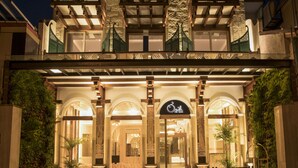 Entrada de un hotel con un letrero que dice "The Bath". Presenta un estilo arquitectónico tradicional con arcos y columnas.