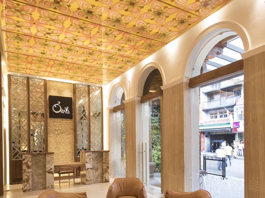A lobby with a patterned ceiling, a reception desk, and seating area.