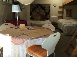 A room with two beds, a table with a candle, a lamp, and a painting on the wall. - Sovdejligt (Hillerod)