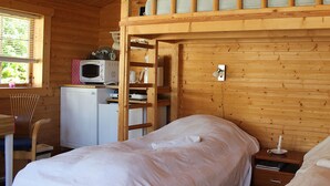 A wooden cabin room with bunk beds, a small kitchenette, and a window with blinds. - Sovdejligt (Hillerod)