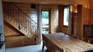 A wooden interior with a staircase, a dining table, and a view through a door. - Valmorel Duplex, 3 bedrooms, 6-8 pers - Skis at your feet, in the heart of the resort (Les Avanchers-Valmorel)