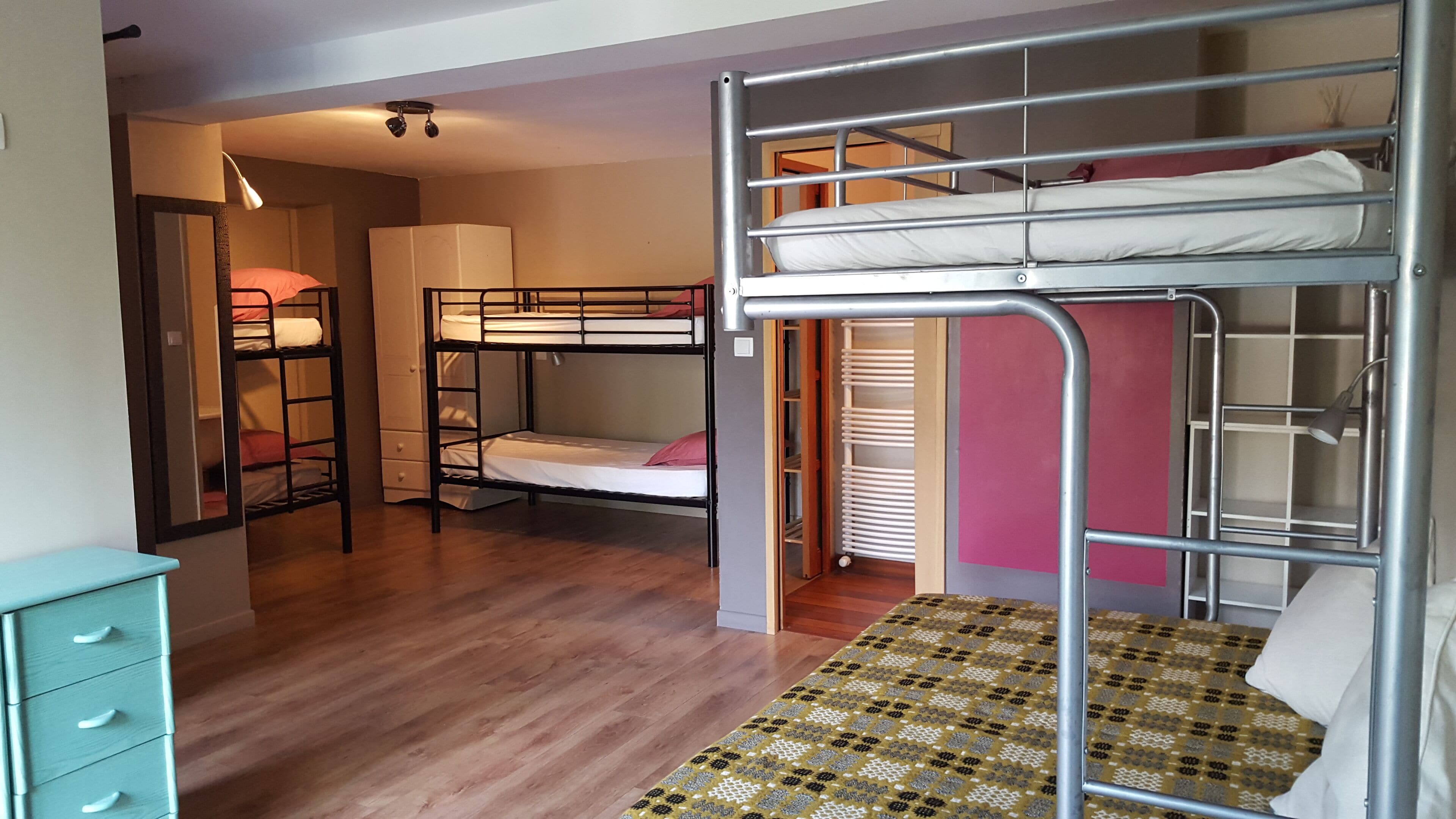Un dormitorio con literas, un escritorio, un armario y una alfombra estampada.