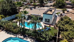 Ein Wohngebiet mit Schwimmbad, einem modernen Haus und Bergblick.