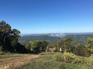 Un paysage vallonné offrant une vue magnifique, sous un ciel dégagé.
