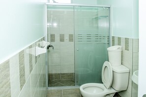 A modern bathroom with a glass-enclosed shower, a toilet, and a sink. - Adventurous Apartment In Miraflores (Lima)