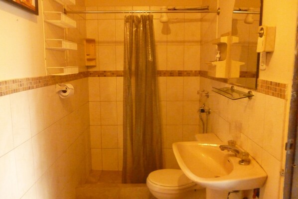 Un baño pequeño con inodoro, lavabo y cortina de ducha.