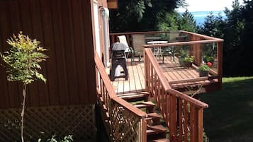 Situated in a natural setting, this cabin offers a deck with outdoor furniture and a view of the ocean.