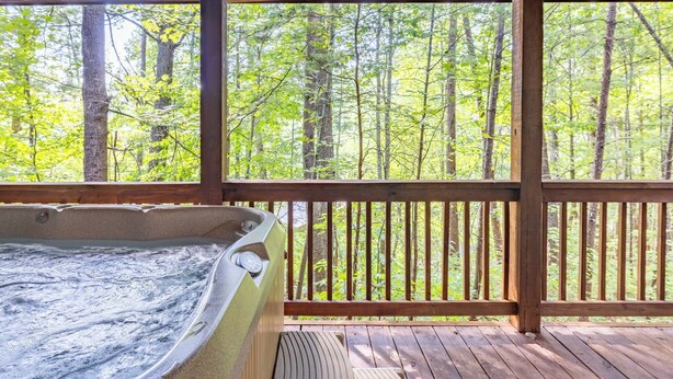 A wooden deck with a hot tub and a view of a forest. - Magic Moments - Pet Friendly Townhome in Innsbruck Golf Community (Helen)