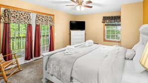 A bedroom with a bed, a dresser, a television, and a ceiling fan. - Magic Moments - Pet Friendly Townhome in Innsbruck Golf Community (Helen)