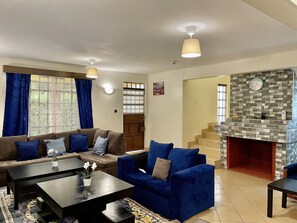A living room with a sofa set, a coffee table, and a fireplace.