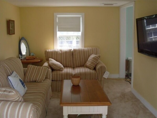 A living room with striped sofas, a coffee table, a mirror, and a TV. - FREE 3rd Night!* (See description) Nantucket in Town 3 Bedroom 1 Bath Cute House (Nantucket)