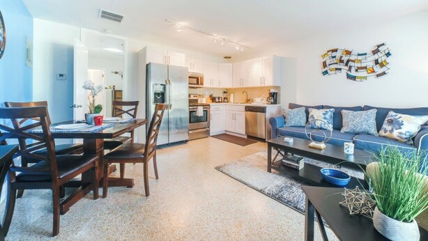 Un appartement moderne comprenant un coin repas, une cuisine et un salon.