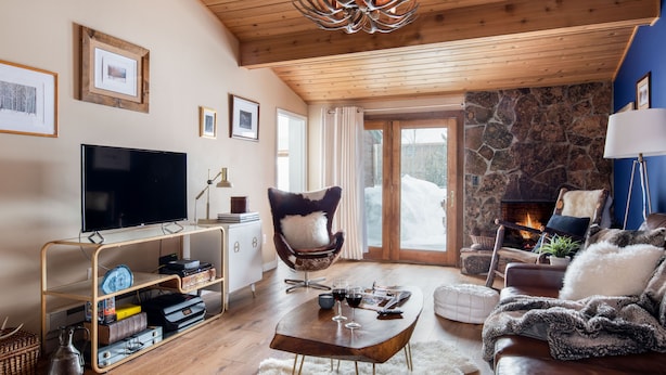 Un accogliente soggiorno con camino in pietra, televisore e una zona salotto confortevole.