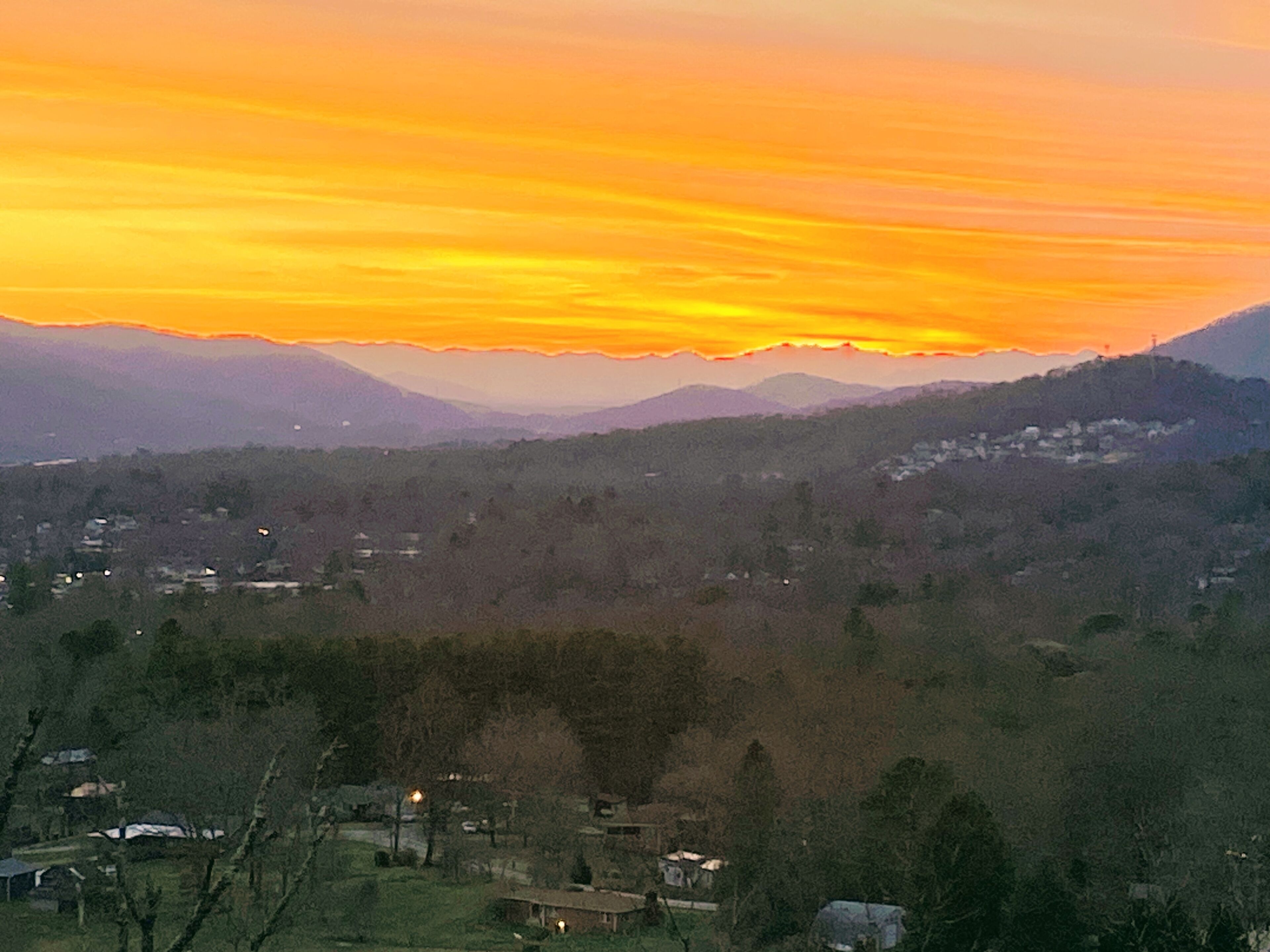 A panoramic view of a valley with a sunset.