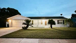 A two-story house with a garage, a front lawn, and a satellite dish on the roof. - Affordable 3 Bedroom Home W / Private Pool. Minutes from Orlando's theme parks (Orlando)