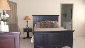 A bedroom with a dark wooden bed, a nightstand with a lamp, and a dresser. - Spacious,Friendly,Warm and Cozy 5 Bedroom 3 Bath Family Home (Banner Elk)