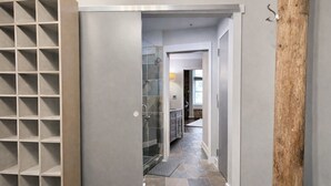 A hallway with a glass shower door, a wooden floor, and a tiled backsplash. - Downtown Music City Loft living! ~Steps to the Ryman and Broadway. (Nashville)