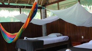 A room with two beds, a hammock, and a thatched roof. - Paradise Amazon Lodge & Adventure (Tambopata)