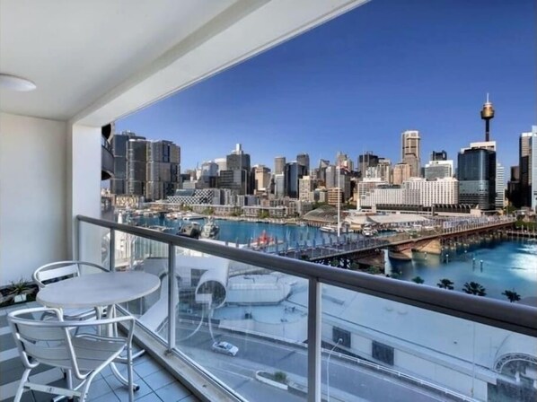 A balcony with a cityscape view, including a marina and a bridge.