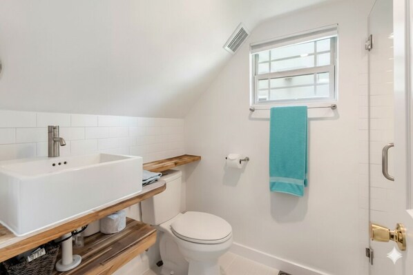 Un baño con lavamanos, inodoro y ventana.
