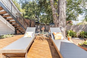 Una terraza con dos sillones, una mesita y una escalera de madera.
