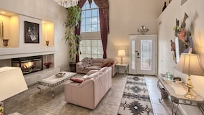 Una sala de estar con chimenea, sofá, mesa de centro y elementos decorativos.