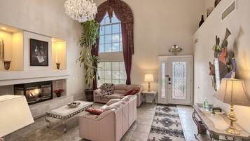 A living room with a fireplace, sofa, coffee table, and decorative items.