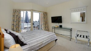 A bedroom with a bed, a TV, a desk, and a chair. - Stunning Penthouse in the Heart of Town – Views, WiFi & Walk to Everything (South West Rocks)