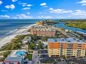 Un hotel costero con varias edificaciones, una playa y un puerto deportivo.