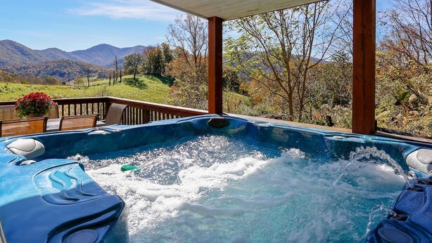 A hot tub with a view of mountains and trees.