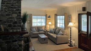 A cozy living room with a stone fireplace, two sofas, a coffee table, and two lamps. - Relax and get away! Beautiful beach house, close to OGT Village and Beach  (Ogunquit)