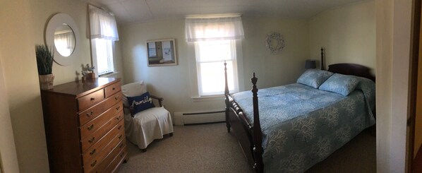 A bedroom with a wooden dresser, a bed with a blue bedspread, a chair with a pillow, a mirror, and a window with curtains. - Relax and get away! Beautiful beach house, close to OGT Village and Beach (Ogunquit)
