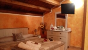 A bedroom with a bed, bedside table, lamp, dresser, and a mirror. - Villa manghisi holiday home (Noto, Siracusa)