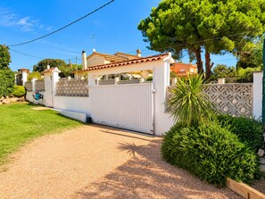A gated residential property with a gravel driveway, a white fence, and a well-maintained lawn. - Formentera on the Costa Brava - BBQ - Garden (Calonge)