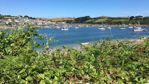 A coastal town with a marina filled with boats, surrounded by greenery and hills. - Apartment set in stunning grounds with coastal views & access to coastal paths (Thurlestone)