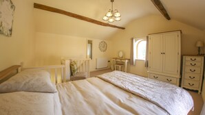 Ein Schlafzimmer mit einem großen Bett, einem Schminktisch, einem Schreibtisch und einem Kleiderschrank.