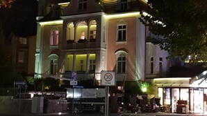 Un bâtiment historique doté d’une tour horlogée, de nombreux balcons et d’un panneau indiquant une zone piétonne.