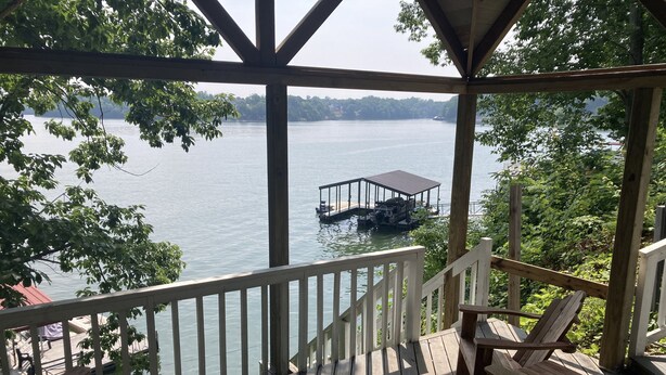 A wooden deck with chairs and a gazebo overlooking a lake with a dock and boat. - Lakefront Retreat w/ Private Dock, Game Room & Sunset Views - Sleeps 16 (Winchester)
