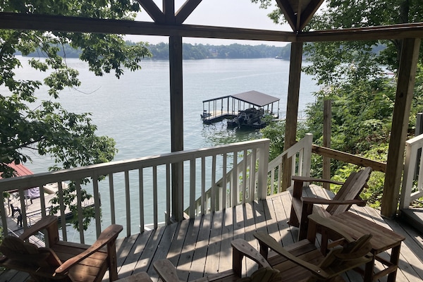 Gazebo with Adirondack rockers and long padded benches by the lake.